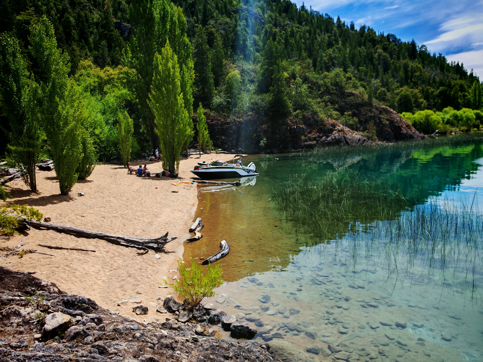 Embarcación de Big Bite Patagonia en una playa tranquila de Lago Puelo